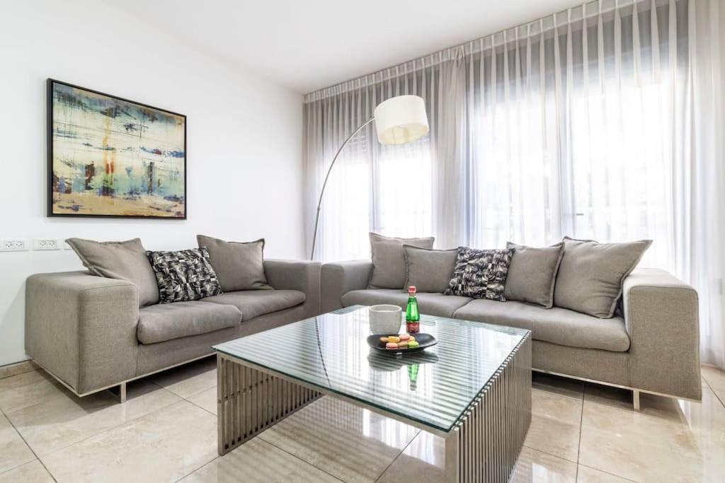 ein Wohnzimmer mit einem Sofa und einem Tisch in der Unterkunft Luxury 3 bedroom apt, Harav Kook7 in Jerusalem