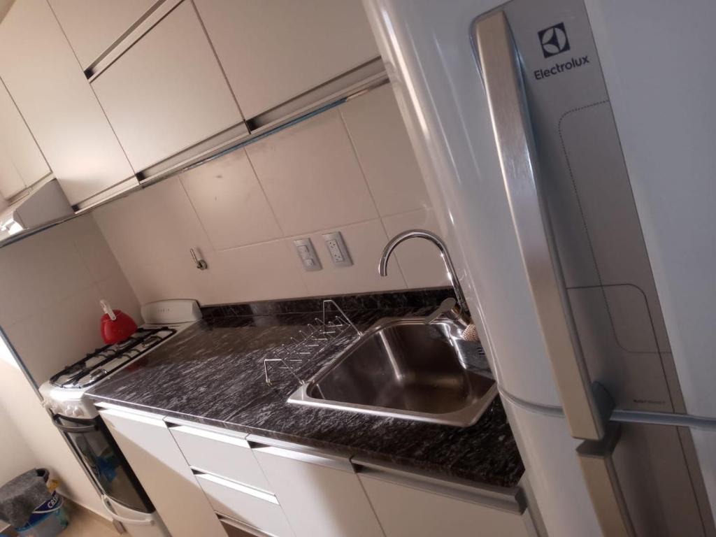 cocina con fregadero y nevera en Edificio Leonardo departamento 16 en Villa Carlos Paz