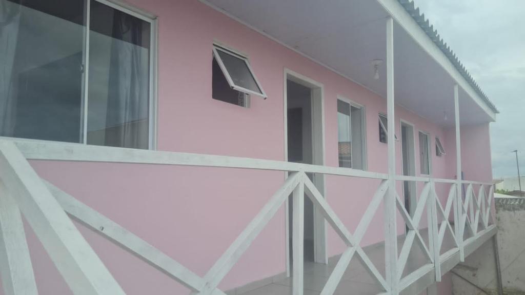 a pink building with a window and a balcony at Pousada Félix in Curitiba