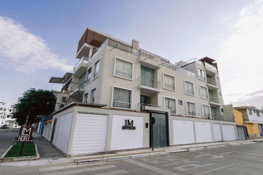 a large white building with two garages in front of it at LM Hoteles in Piura