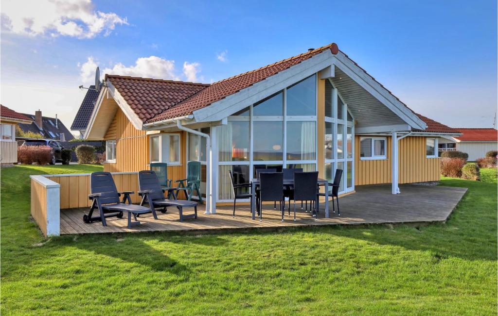 ein Haus mit einer Terrasse mit Stühlen und einem Tisch in der Unterkunft Strandblick 31 in Schönhagen