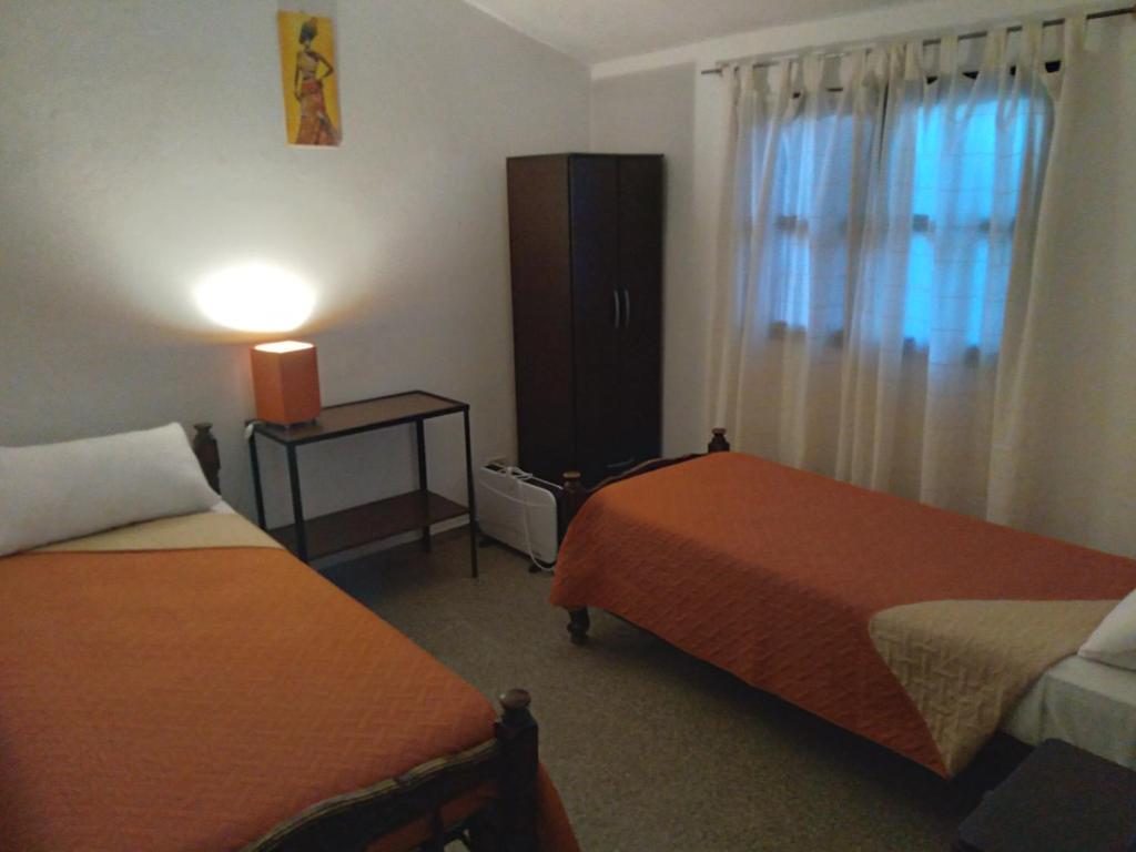 Habitación de hotel con 2 camas y ventana en LENA'S en Tinogasta