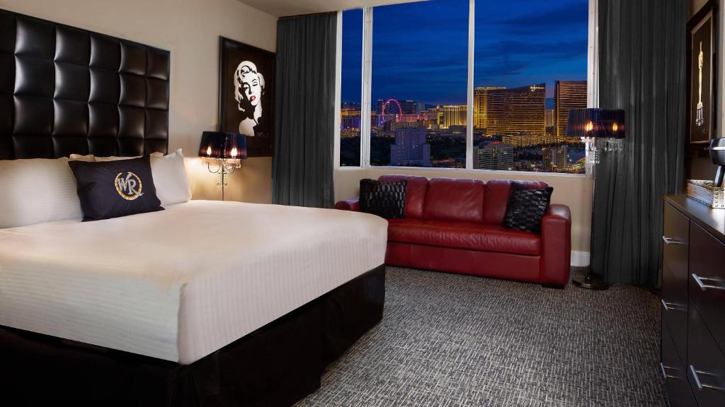 a hotel room with a bed and a red couch at Beautiful Room by WESTGATE Casino close to Las Vegas Convention Center in Las Vegas