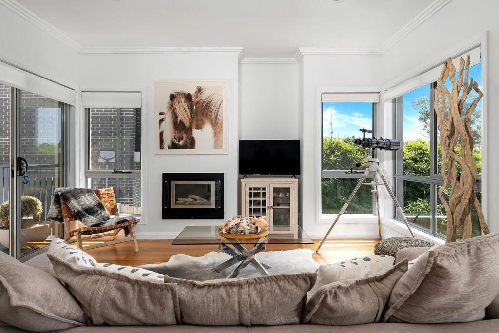 a living room with a couch and a horse on the wall at Sapphire on Wilson Gerringong in Gerringong
