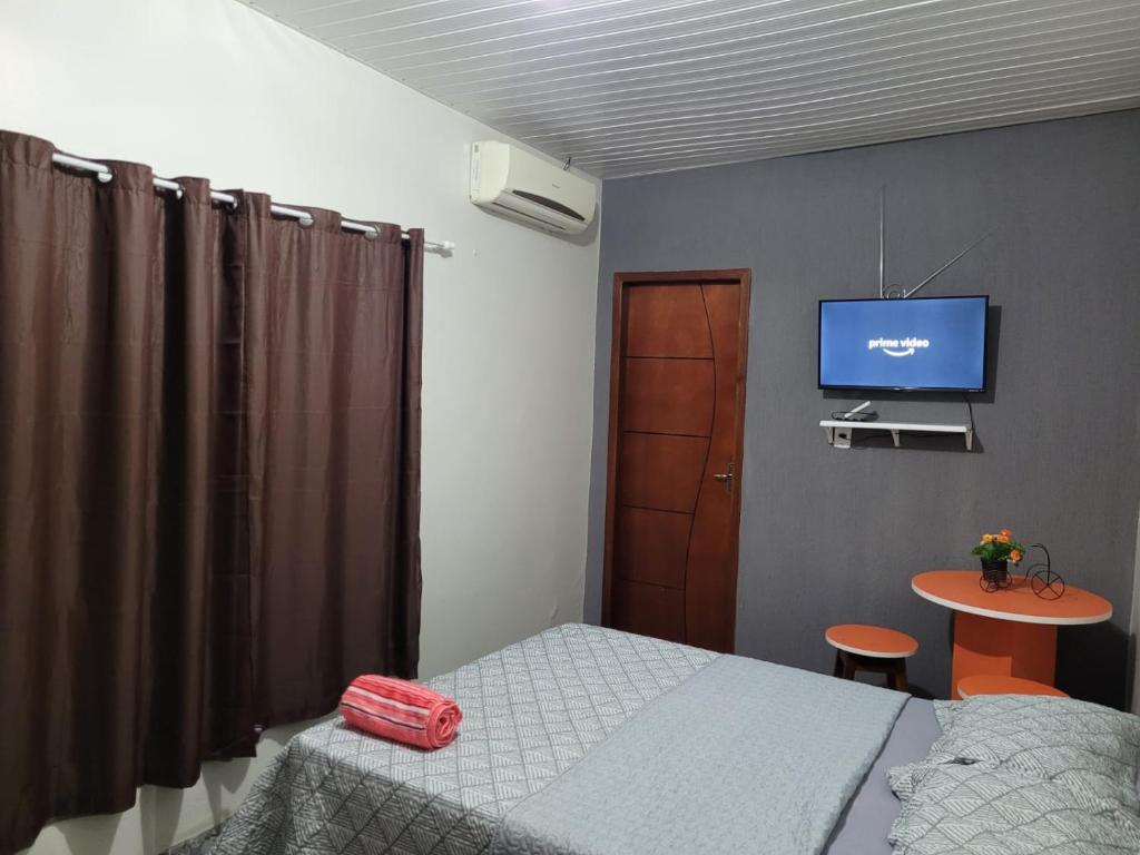 um quarto com uma cama e uma televisão na parede em Olga Moreira 01 - inclui garagem em Paragominas