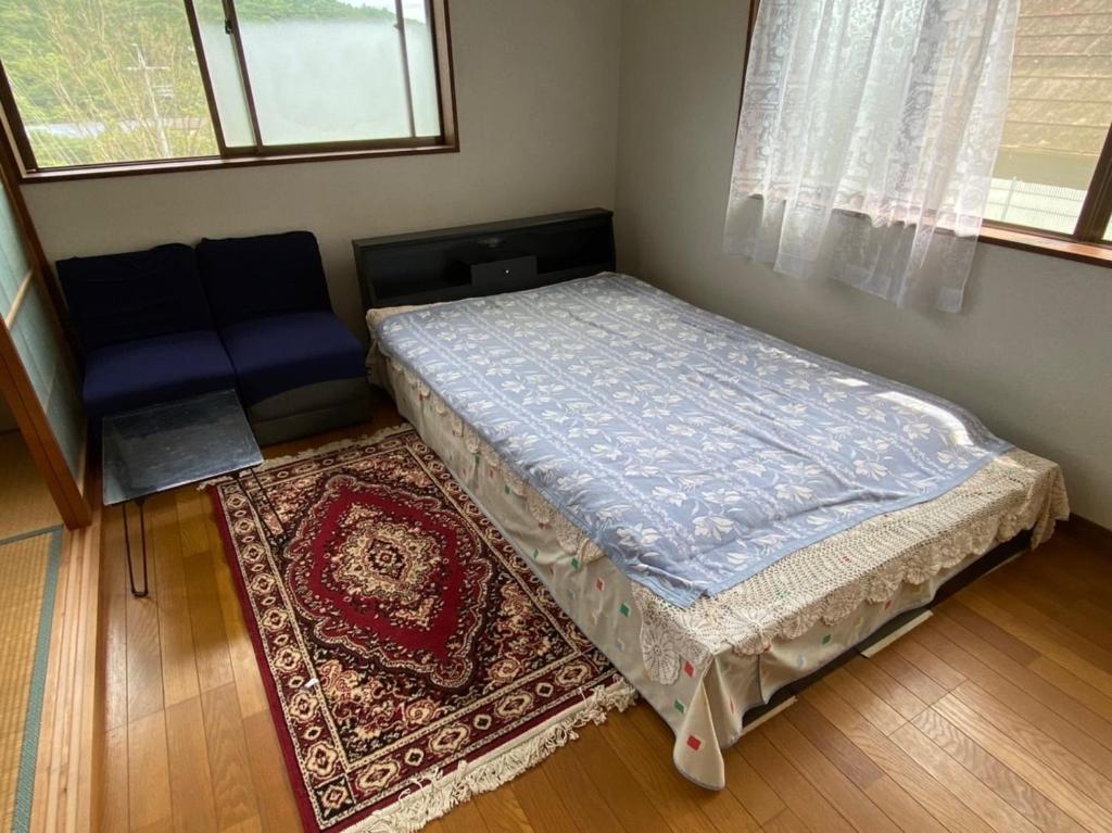 a small bedroom with a bed and a rug at Hotel Ryokan Togenkyo - Vacation STAY 97146v in Ise