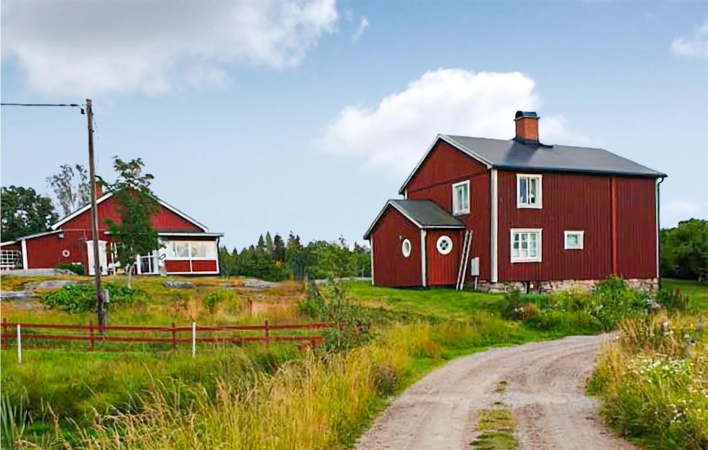 Gorgeous Home In Finnestad With Wifi في سيفلي: حظيرة حمراء على حقل بجانب طريق ترابي