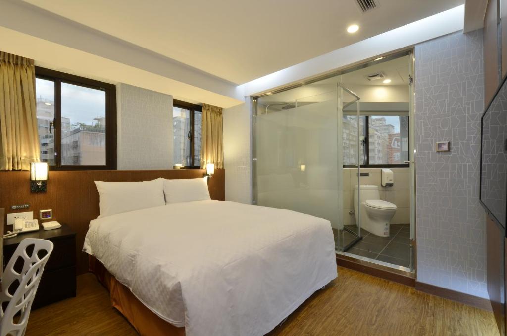 a bedroom with a bed and a shower and a toilet at Hua Da Hotel- Nanxi in Taipei
