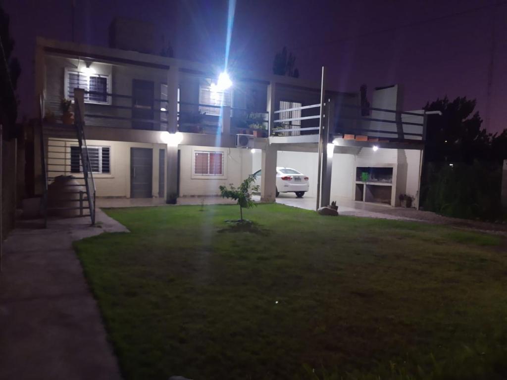 a house with a car parked in the yard at night at Mercedario Aparts in Barreal