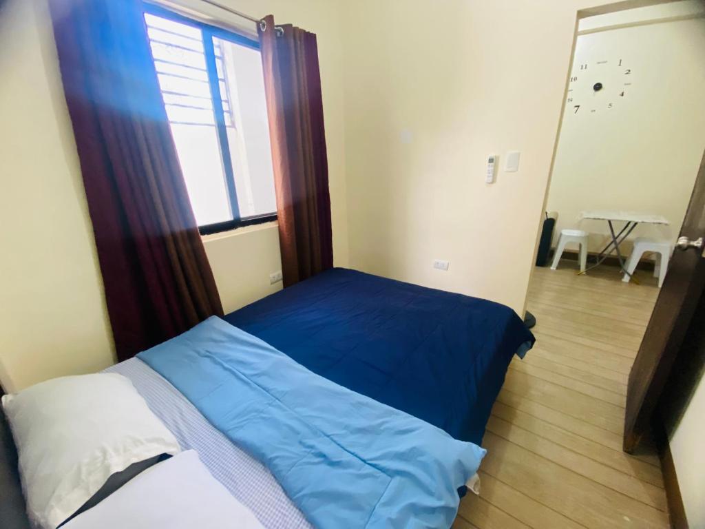 a bedroom with a blue bed and a window at San Jose del monte Bulacan gumaok with aircon unit 1 in Mangangpico