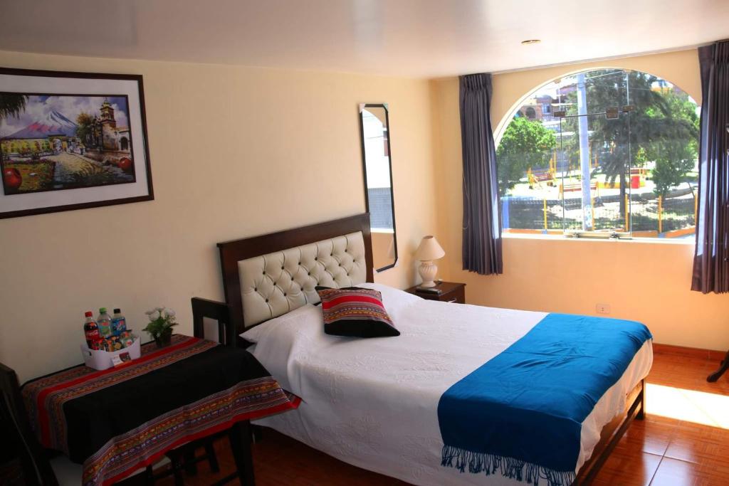 Un dormitorio con una cama grande y una ventana en Qori Arequipa, en Arequipa
