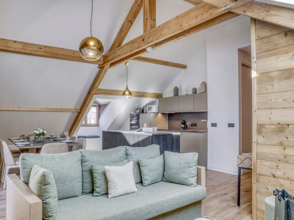 un salon avec un canapé bleu et une cuisine dans l'établissement Appartement moderne avec accès direct aux remontées mécaniques à Saint-Gervais-les-Bains - FR-1-663-19, à Saint-Gervais-les-Bains