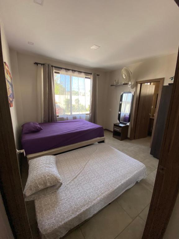 a bedroom with a purple bed and a television at Departamento Playas Villamil vacaciones in Playas