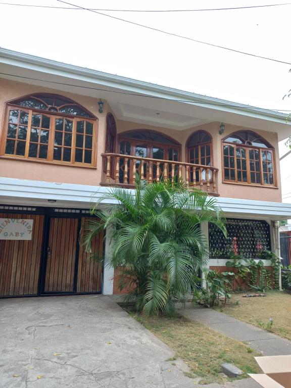 una casa con una palmera delante de ella en Casa 114, en Managua