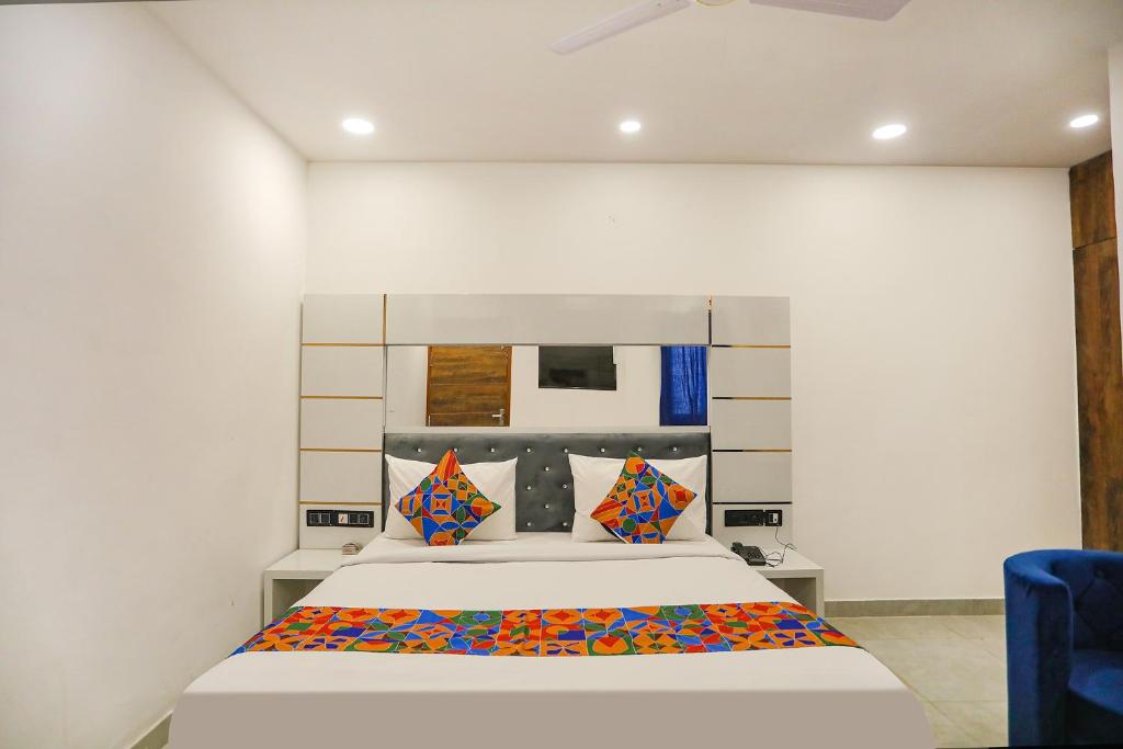 1 dormitorio con 1 cama y 1 silla azul en FabExpress F9 Noida Sector 27, en Noida