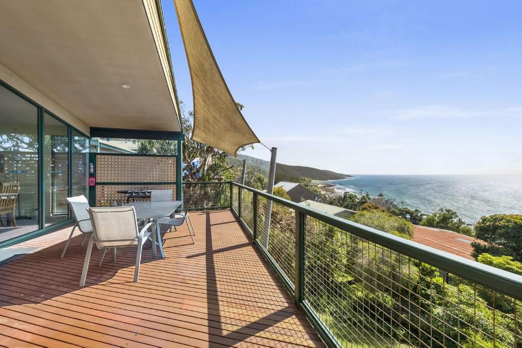 a balcony with a table and chairs and the ocean at Cara in Wye River