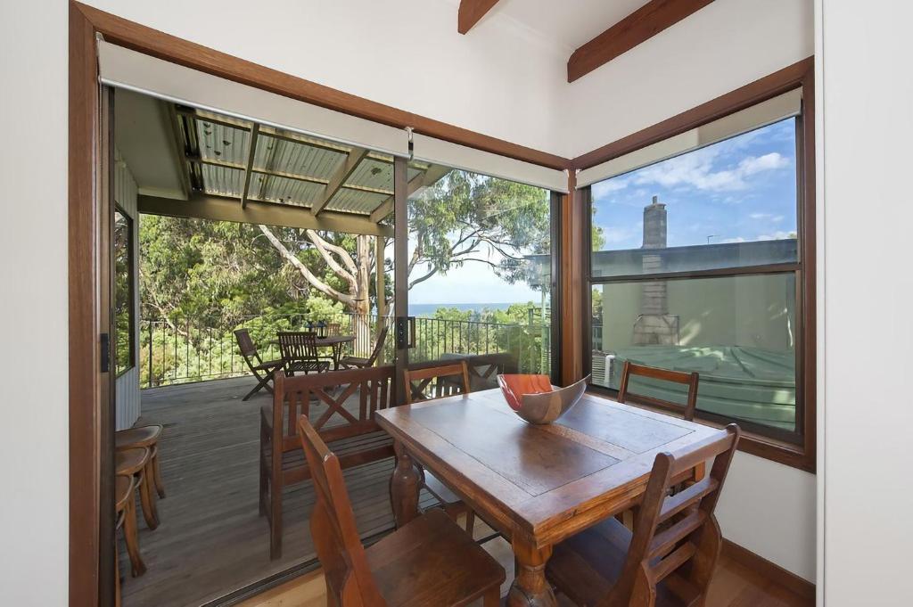 a dining room with a table and chairs on a deck at At Riverside in Wye River