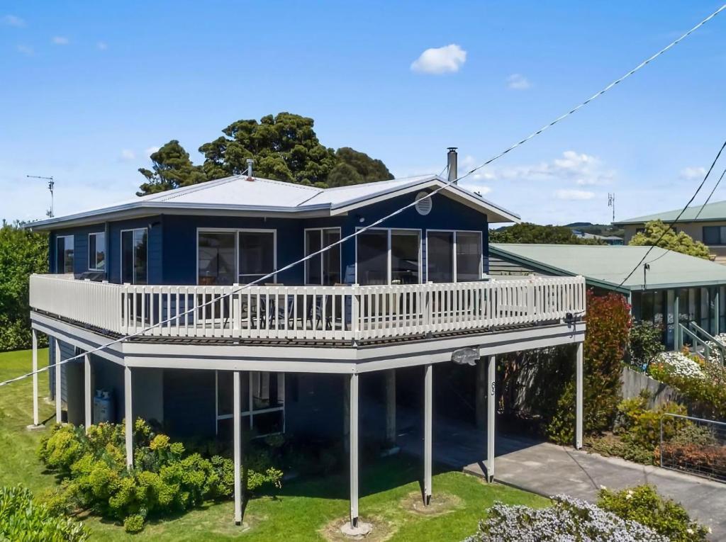 a large blue house with a white deck at Bimbadeen in Apollo Bay