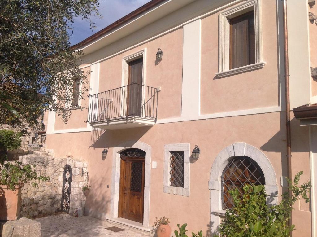 a large peach colored house with a balcony at B&B Le Viole in Arce