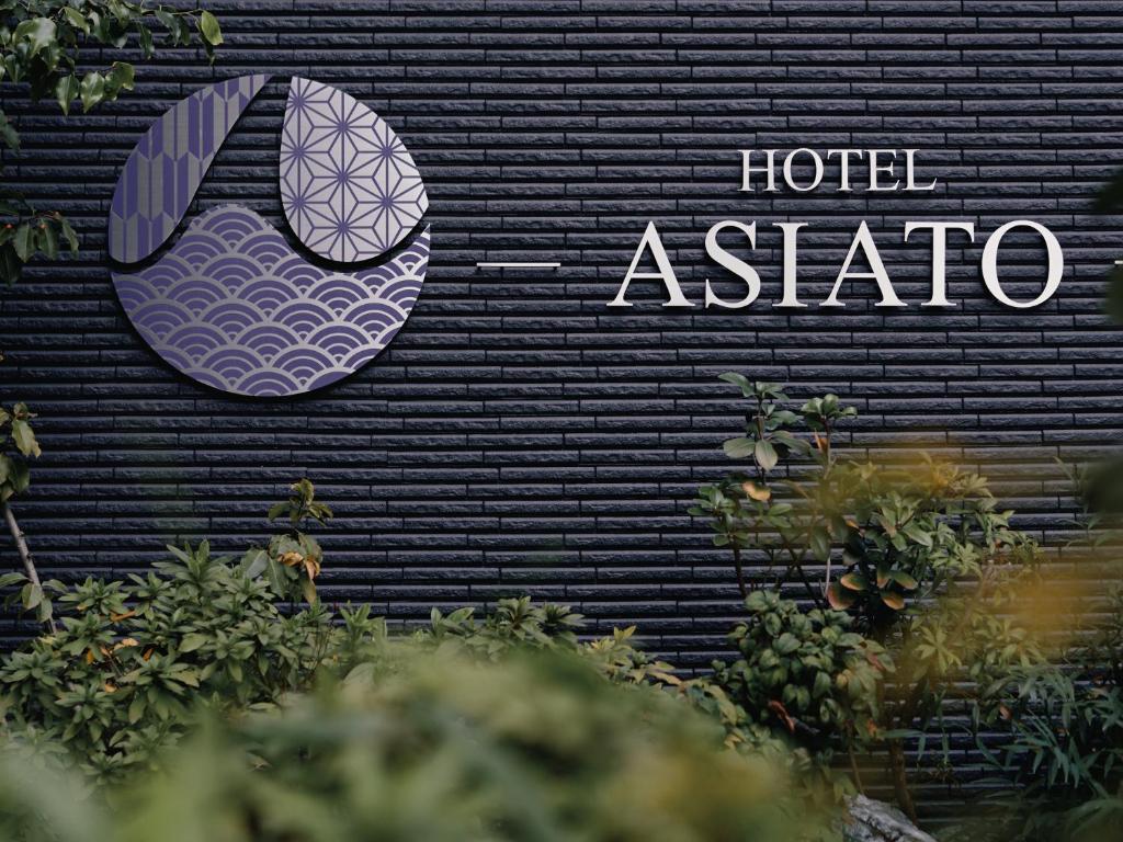 un panneau d'asibo sur un mur noir dans l'établissement Hotel -ASIATO-, à Osaka
