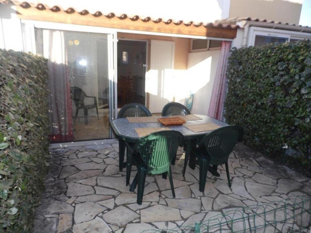 une terrasse en pierre avec une table et des chaises. dans l'établissement Villa 4-6 couchages avec piscine, tennis et parking privé, proche plage – Marseillan - FR-1-326-532, à Marseillan