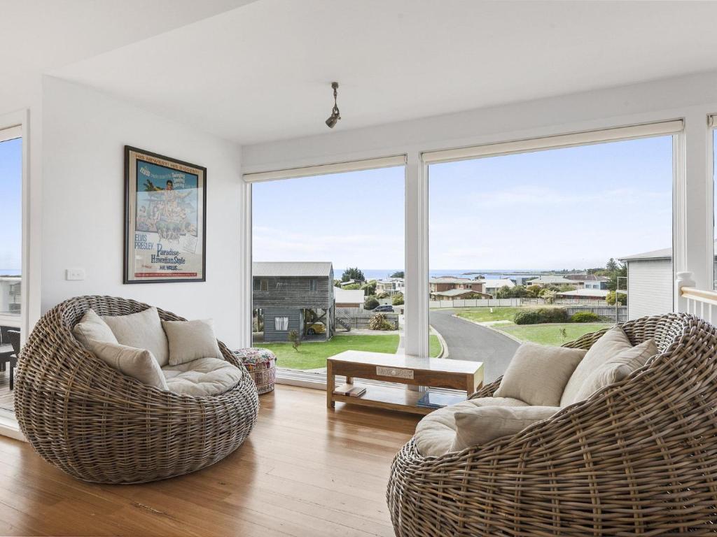 a living room with two chairs and a large window at Art House in Apollo Bay