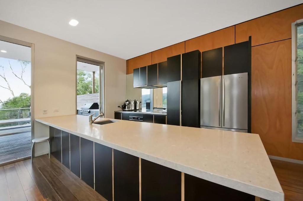 a kitchen with a counter and a refrigerator at Coastal Break in Wye River