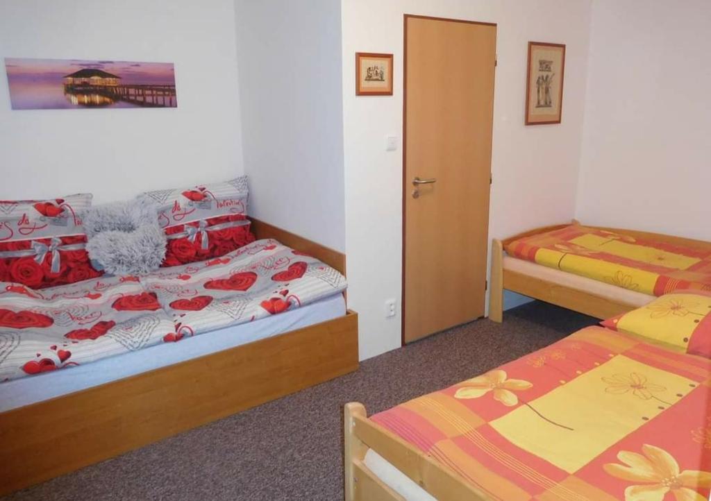 a bedroom with two beds and a door to a room at Ubytování v Plumlově in Plumlov