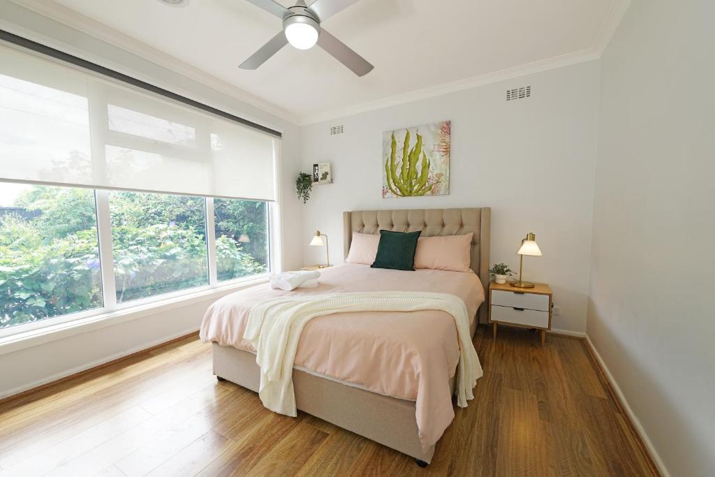 a white bedroom with a bed and a large window at Pet-friendly Bayside 4BR Rental House near Mentone in Parkdale