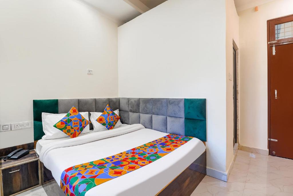 um quarto com uma cama grande e um cobertor colorido em FabExpress Royal Villas em Gwalior