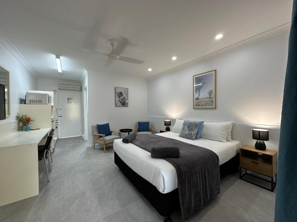 a bedroom with a bed and a desk and a kitchen at Mareeba Motor Inn in Mareeba