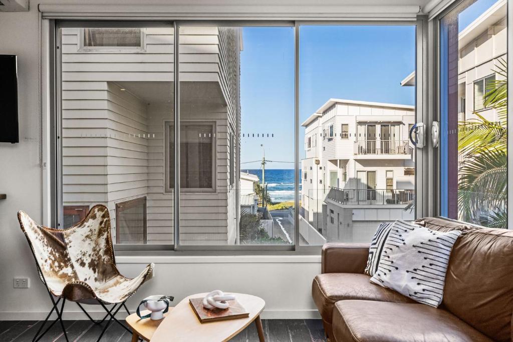 a living room with a couch and a large window at Daybreak Loft in Gold Coast