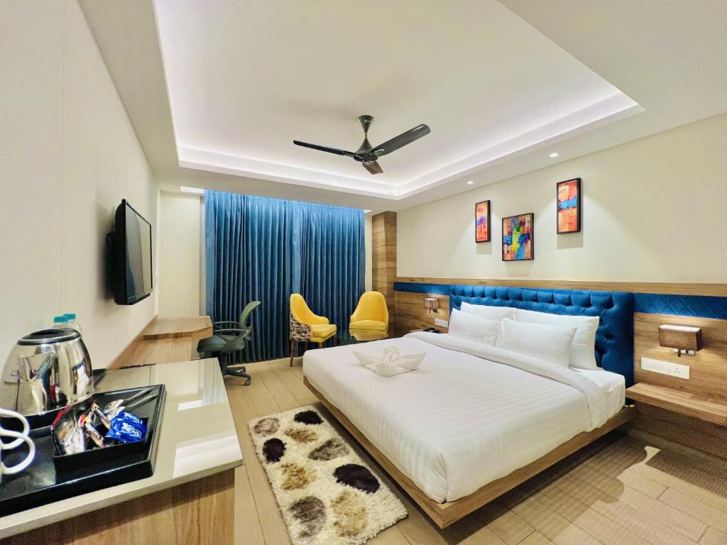 um quarto com uma cama e uma secretária com uma televisão em SJ PARADISE em Dehradun