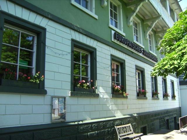 a building with windows and a bench in front of it at Europäisches Gäste- und Seminarhaus in Todtmoos