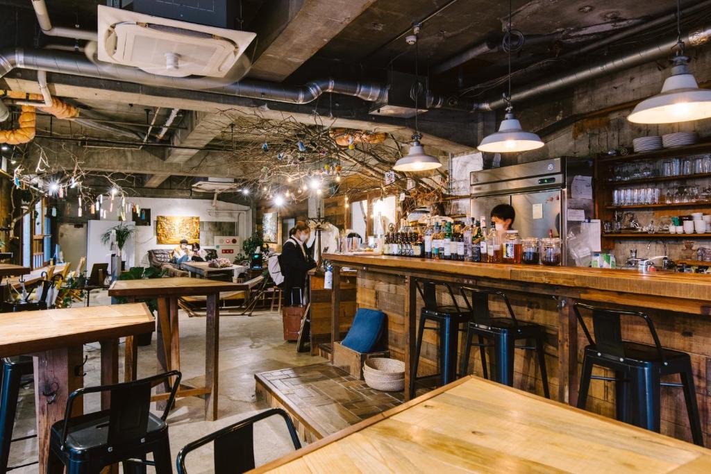 a bar with wooden tables and chairs in a restaurant at Guesthouse RICO in Wakayama