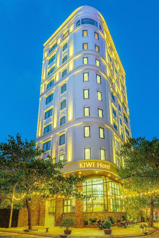 a tall building with a sign in front of it at Kiwi Beachside Hotel & Cafe Da Nang in Danang
