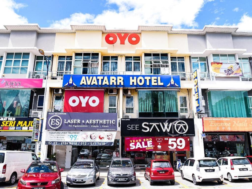 un gran edificio con coches estacionados frente a él en HOTEL AVATARR en Batu Caves