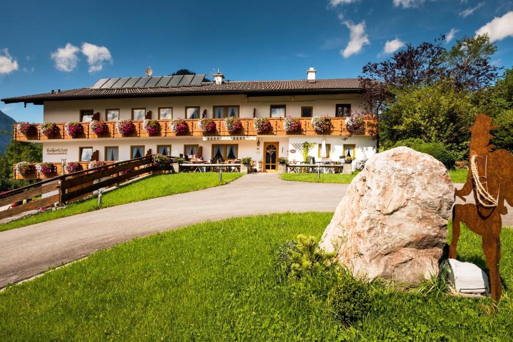 ein Haus mit einem großen Felsen davor in der Unterkunft Gästehaus Heißenlehen in Ramsau bei Berchtesgaden