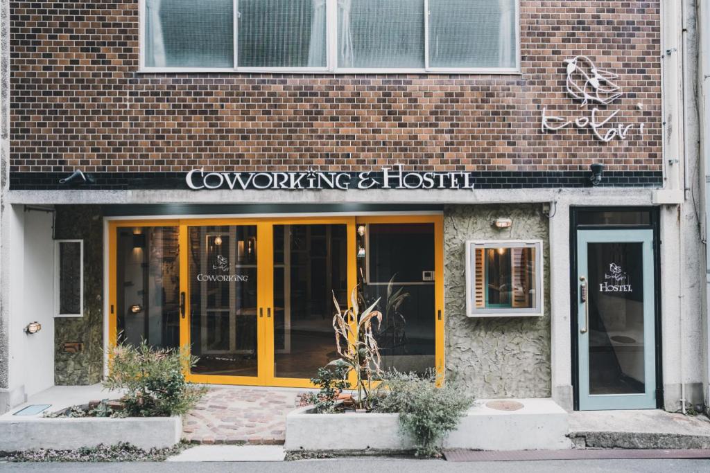 a store front of a brick building with yellow doors at コトリ コワーキング&ホステル高松 in Takamatsu