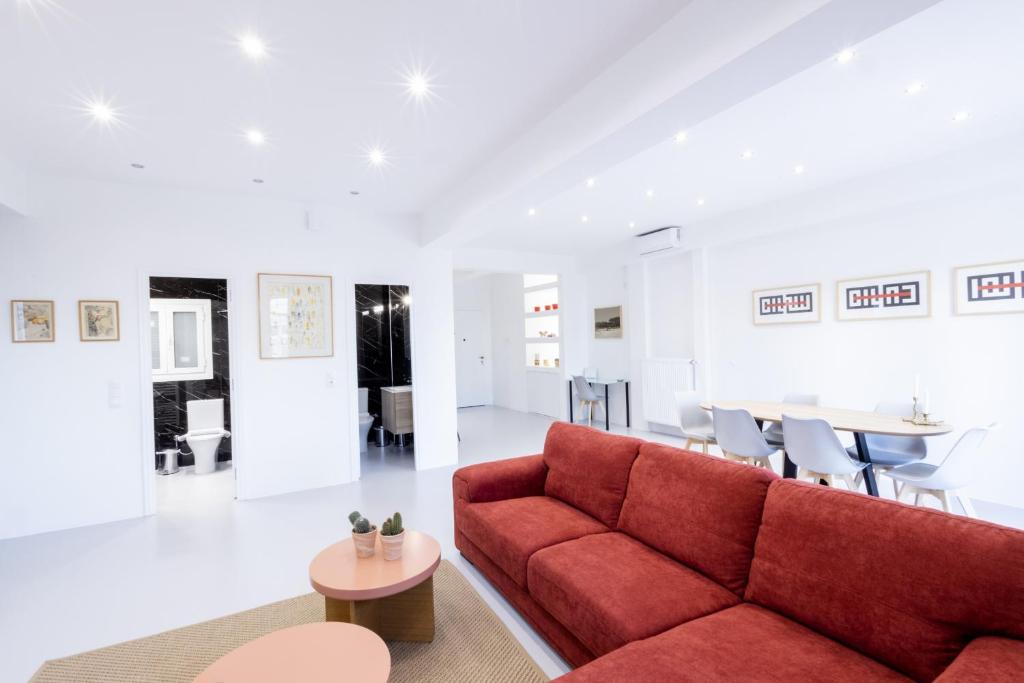 uma sala de estar com um sofá vermelho e uma mesa em Comfort Sunny Hub with 2 bdr em Atenas