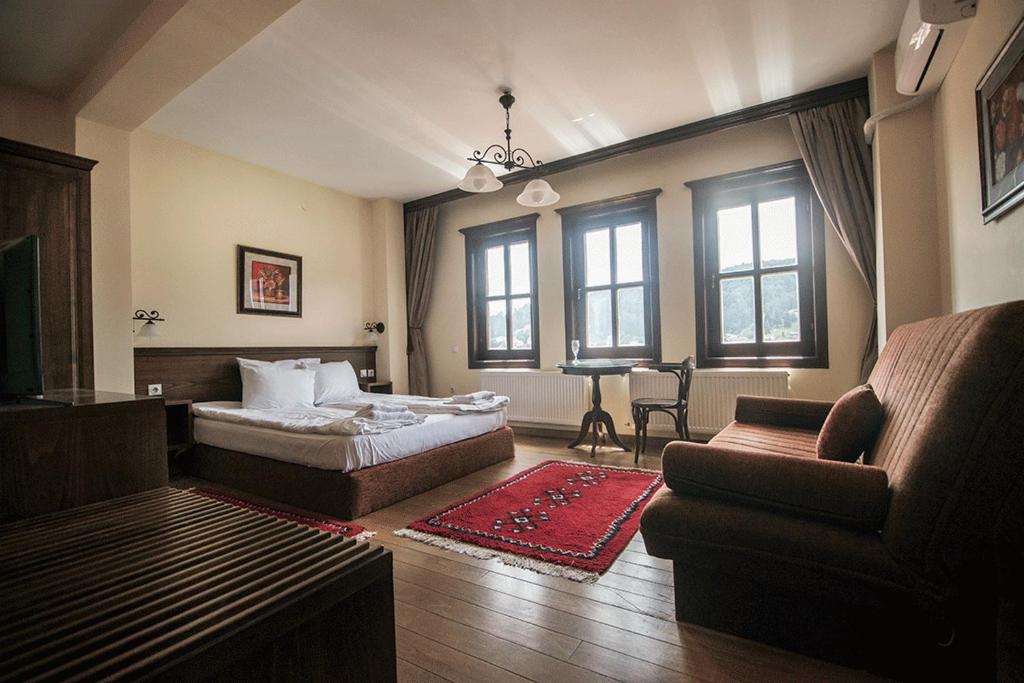 a bedroom with a bed and a couch and a chair at Casa La Kola Krusevo in Kruševo