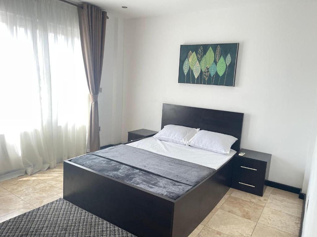ein Schlafzimmer mit einem großen Bett mit weißer Bettwäsche in der Unterkunft Luxury @ the Garden in Accra