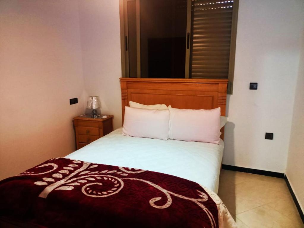 - une chambre avec un lit et une tête de lit en bois dans l'établissement Hammadi's house, à Oualidia