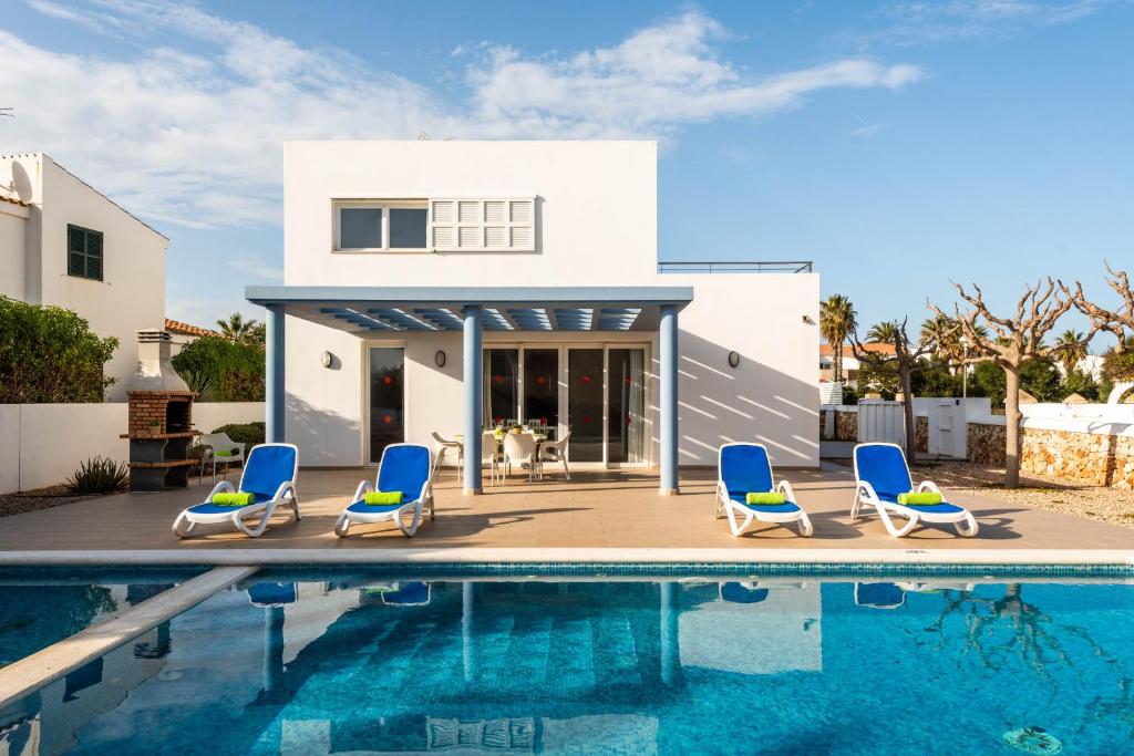 a villa with a swimming pool and a house at Villas Calan Bosch Ona in Cala'n Bosch