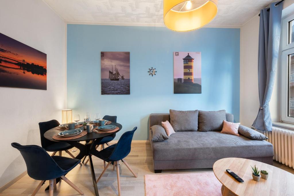 - un salon avec un canapé et une table dans l'établissement Infinity Stay Maritim Bis zu 4 Personen Zentrumsnah Netflix, à Wilhelmshaven