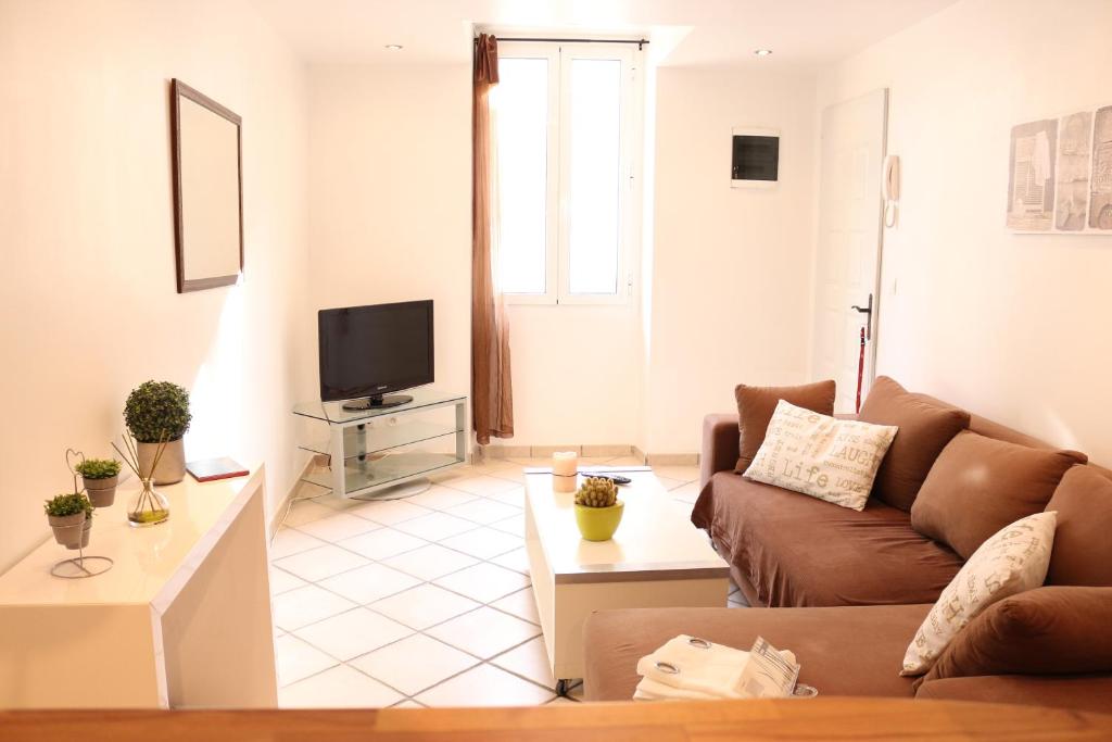 a living room with a couch and a tv at Appartement Esterelle in Cassis