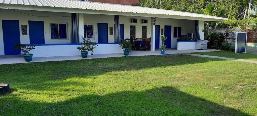 a house with blue doors and a grass yard at Spacious Resort in Pansol up to 20 pax in Pansol