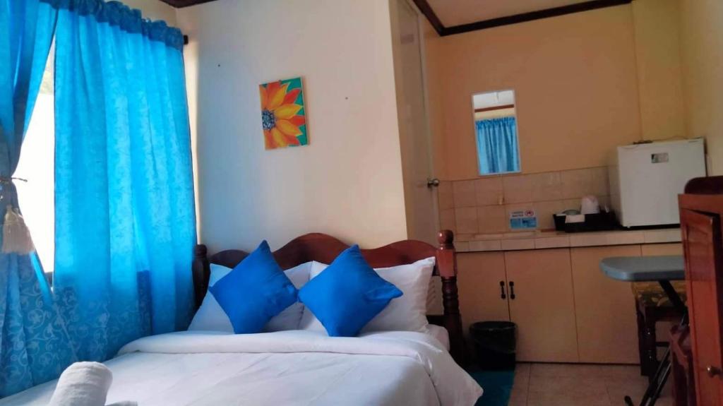 CORALYN'S PLACE standard room في بوراكاي: غرفة نوم بسريرين مع ستائر زرقاء