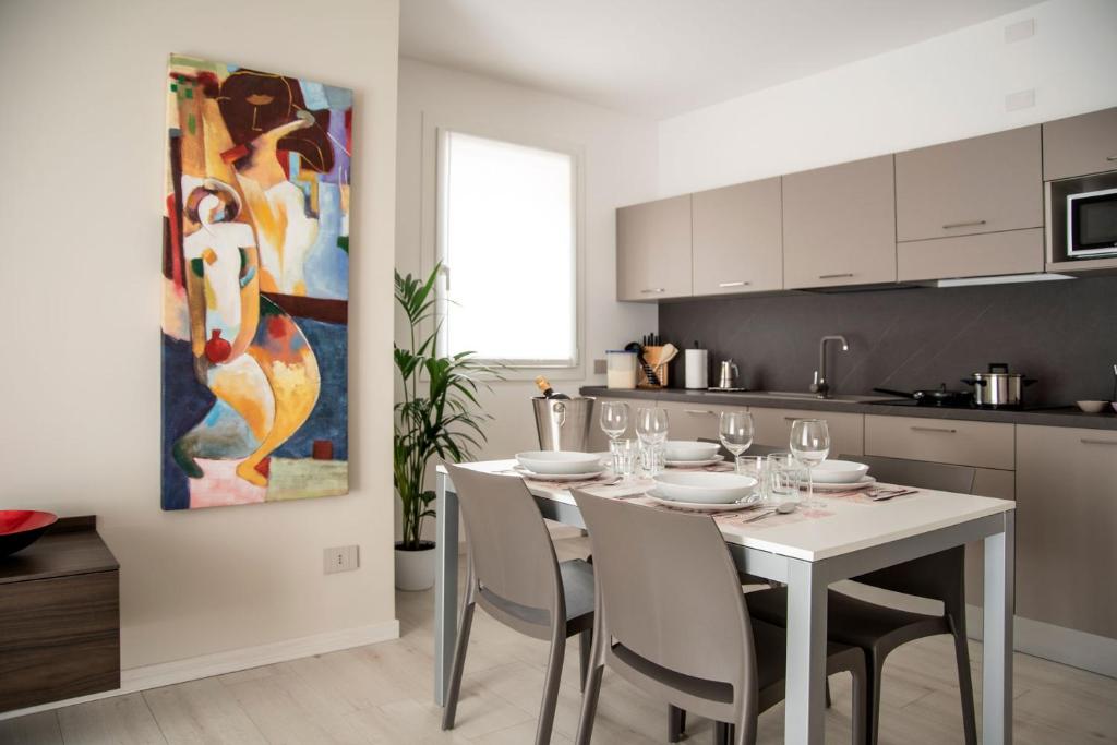una cucina con tavolo, sedie e quadro di Camelot Red - Appartamenti a Verona