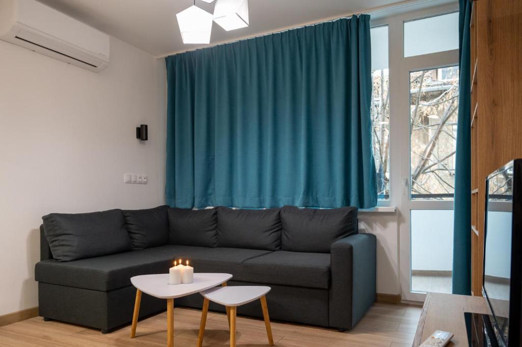 a living room with a couch and a table at Modern and Cozy 1BDR Apartment in the City Center in Sofia